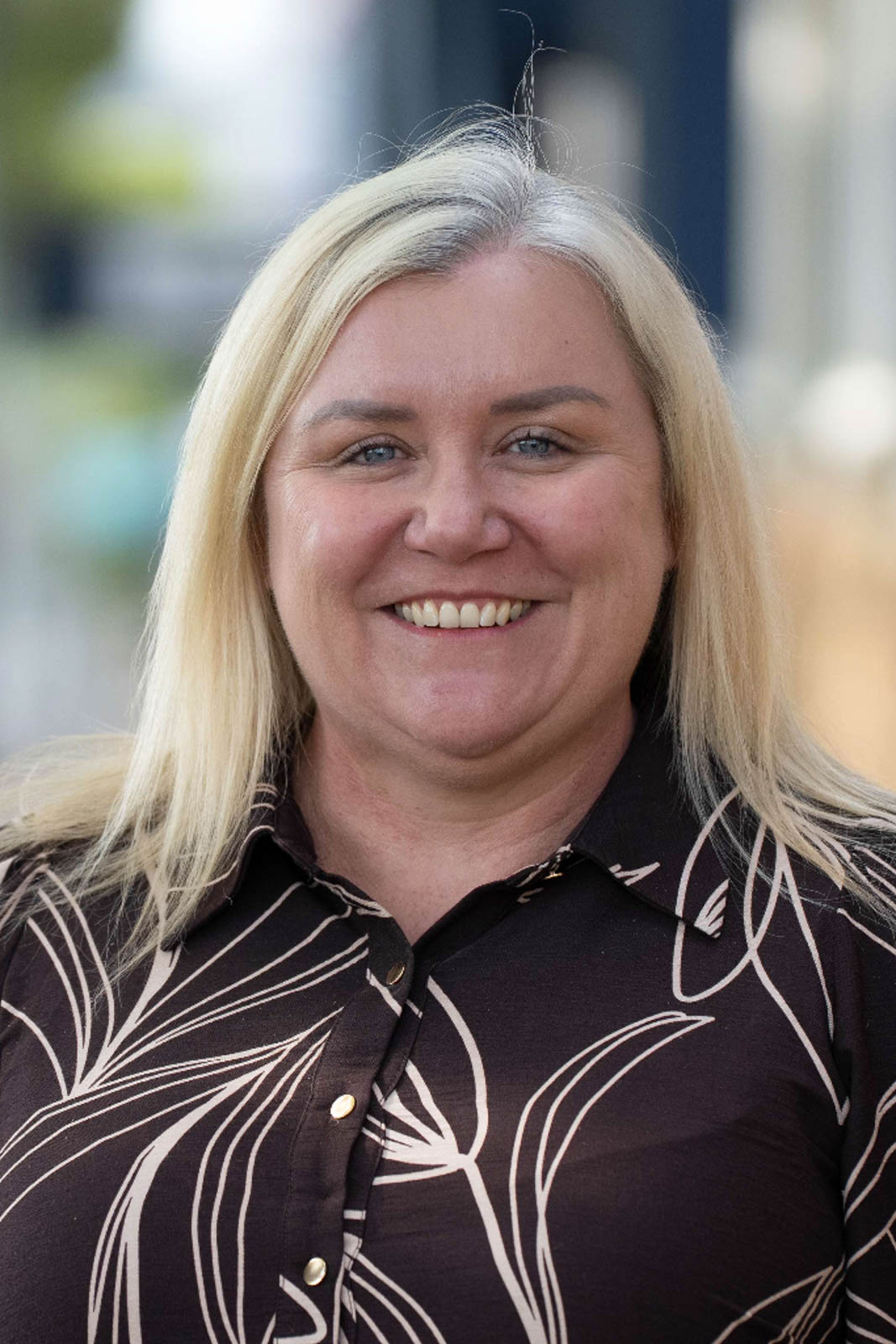 Outdoor headshot of Heather in a brown patterned shirt.