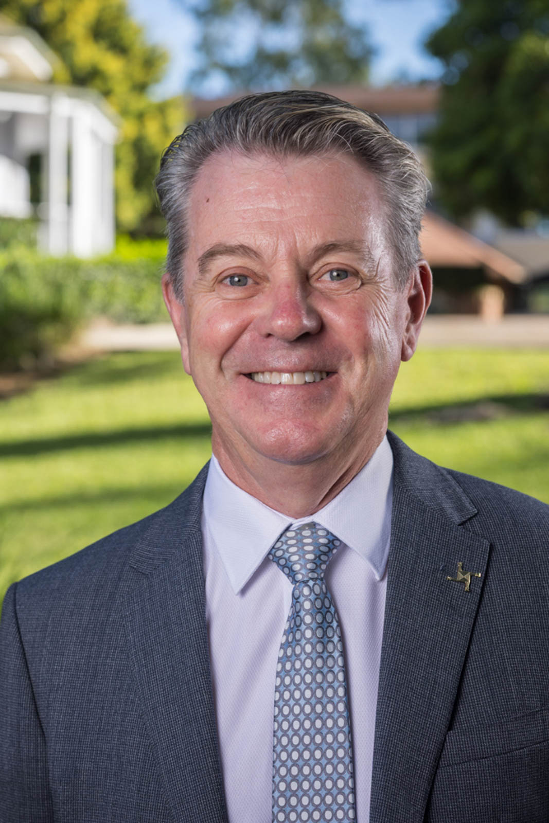 Outdoor headshot of Brendan in a suit.