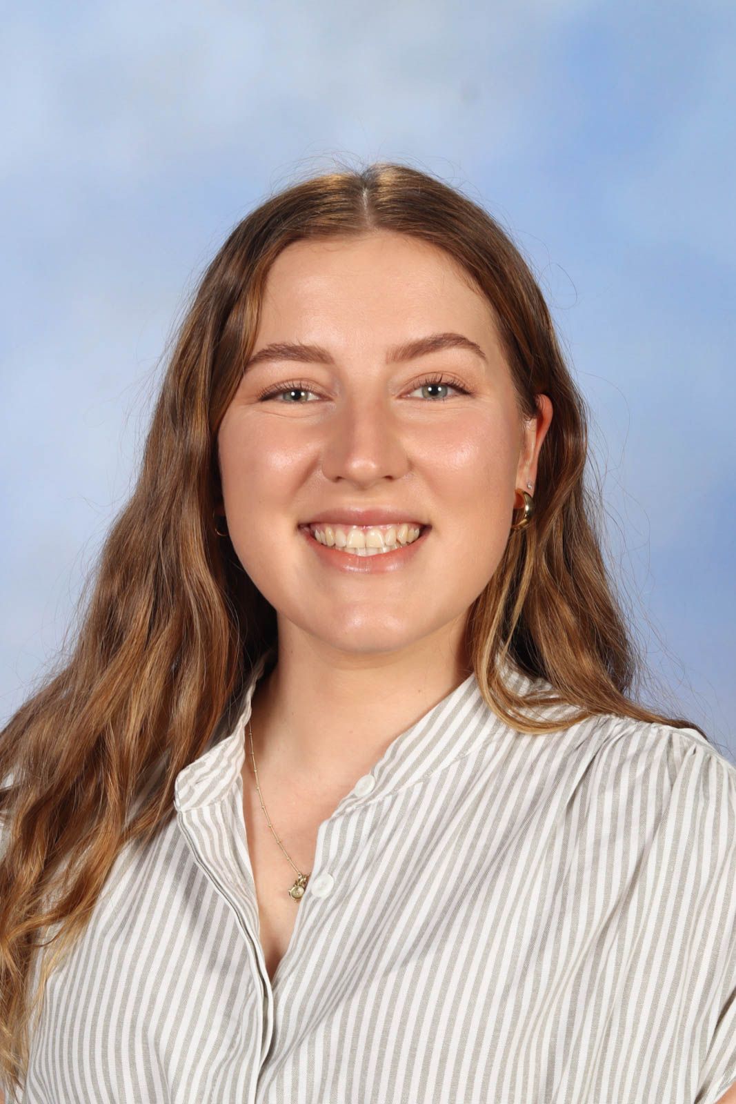 Headshot of Grace in a white striped shirt.
